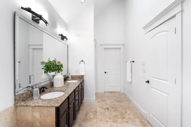a bathroom with a granite countertop sink a mirror and a shower