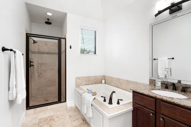 a bathroom with a tub sink and mirror