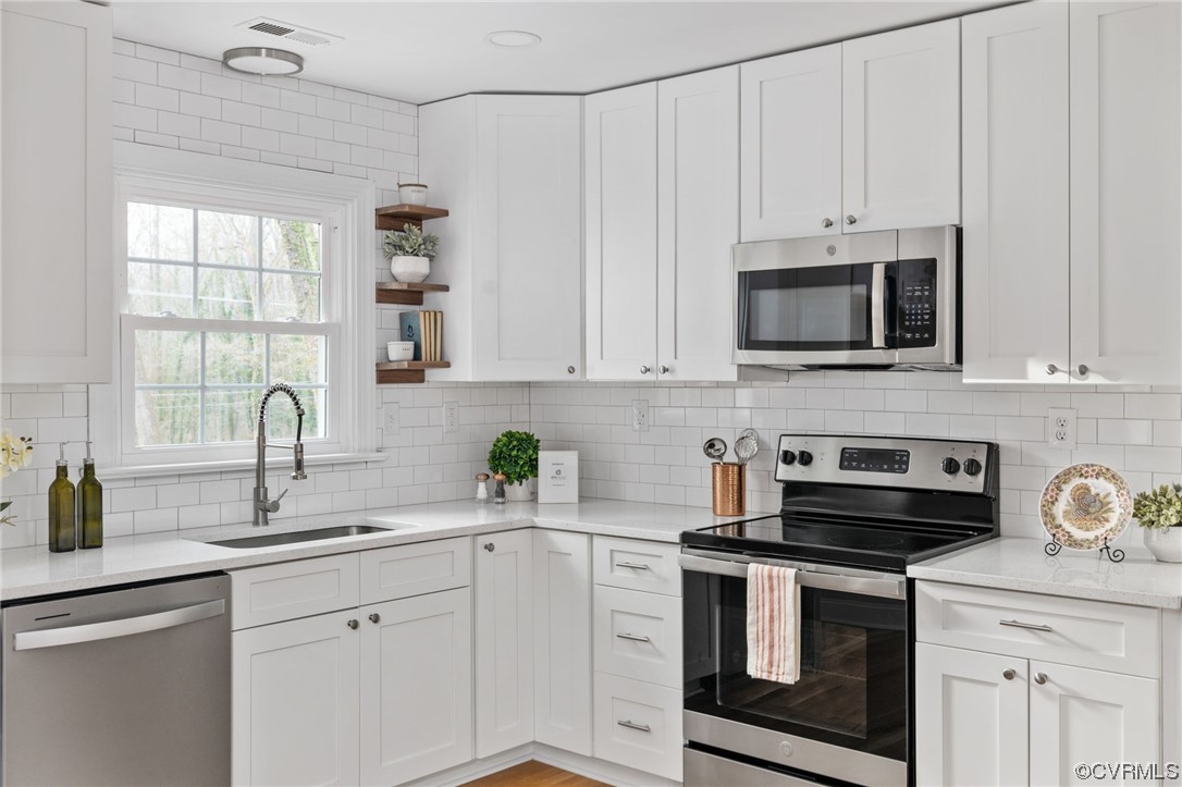 1818 Bloomfield Road Richmond, VA 23225 - Photo 13 of 45 a kitchen with stainless steel appliances granite countertop white cabinets a sink and a stove