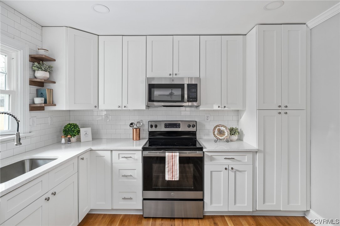 1818 Bloomfield Road Richmond, VA 23225 - Photo 15 of 45 a kitchen with white cabinets and black appliances