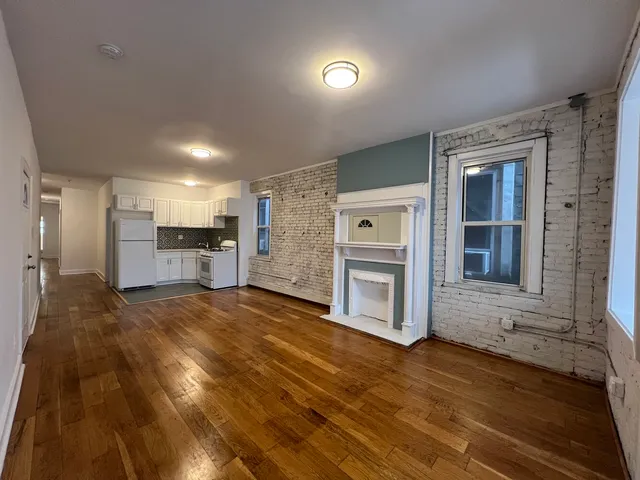 a view of a hallway with wooden floor and cabinet