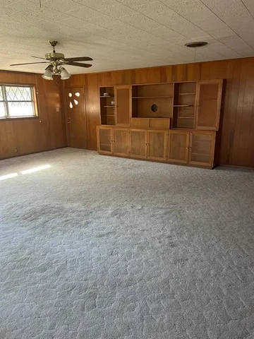 a view of a livingroom with an empty space and a window