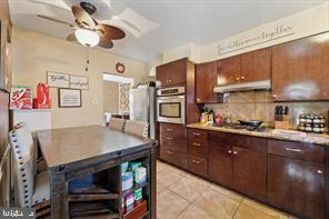 503 Bonsall Avenue Lansdowne, PA 19050 - Photo 9 of 24 a kitchen with stainless steel appliances wooden cabinets a center island and chairs