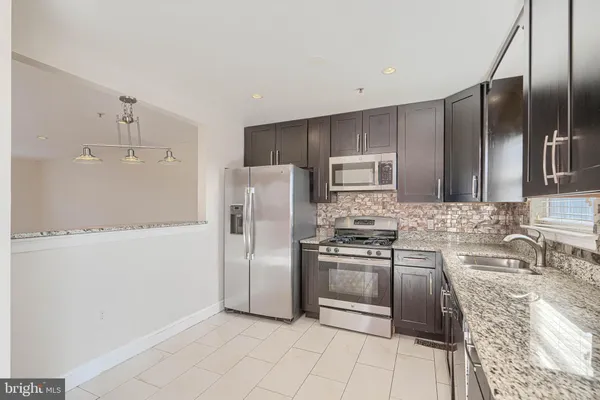 a kitchen with stainless steel appliances granite countertop a refrigerator and a stove top oven
