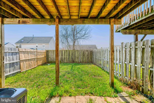 a view of a house with a backyard and a wooden deck