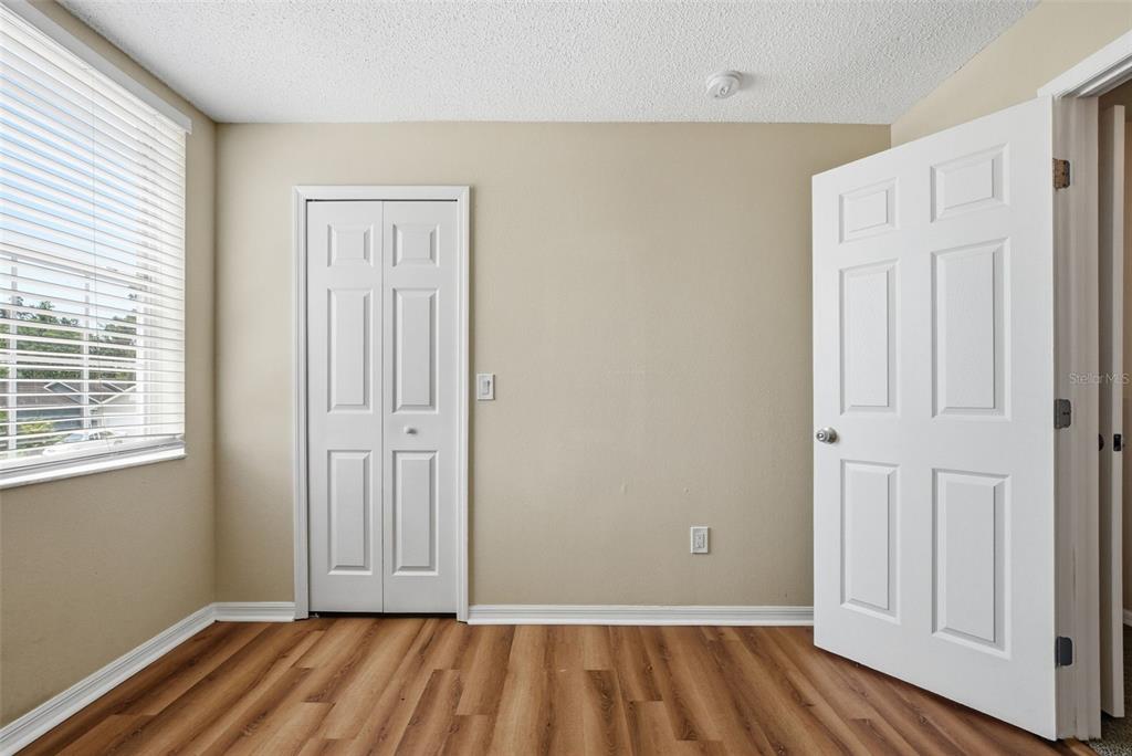 617 Greys Ferry Road Orlando, FL 32811 - Photo 19 of 35 an empty room with wooden floor and windows