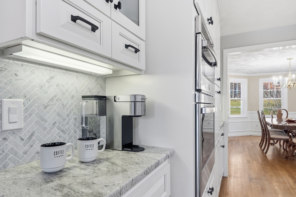 33 Overlook Drive Groton, MA 01450 - Photo 13 of 41 a kitchen with stainless steel appliances kitchen island a table chairs in it and wooden floor