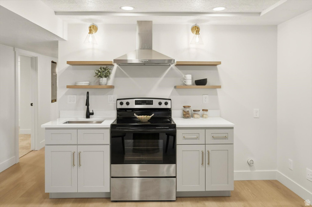 8760 Rustler Road Cottonwood Heights, UT 84093 - Photo 34 of 57 Kitchenette featuring light-toned cabinetry, a stainless steel range with overhead ventilation, and a single basin sink with a matte black faucet