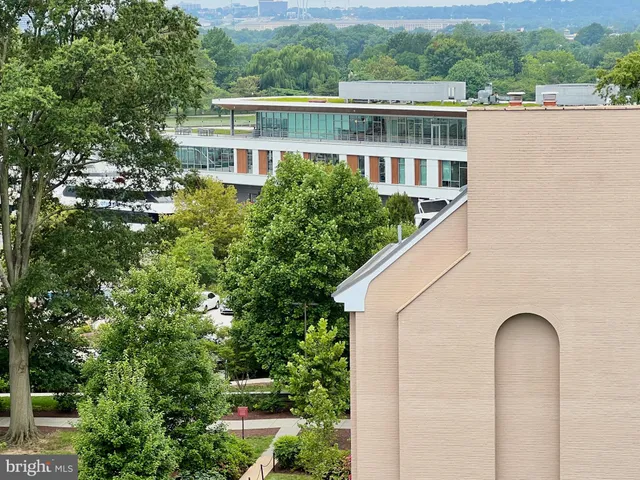 a front view of a multi story residential apartment building with yard and entertaining space