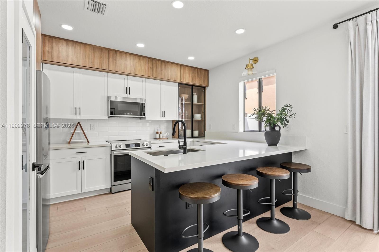 10487 West 34th Court Hialeah, FL 33018 - Photo 12 of 57 a kitchen with stainless steel appliances kitchen island granite countertop a sink and cabinets