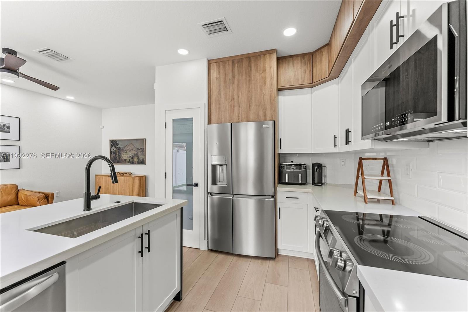 10487 West 34th Court Hialeah, FL 33018 - Photo 15 of 57 a kitchen with stainless steel appliances granite countertop a sink dishwasher a refrigerator a stove top oven a refrigerator with wooden floor and cabinets