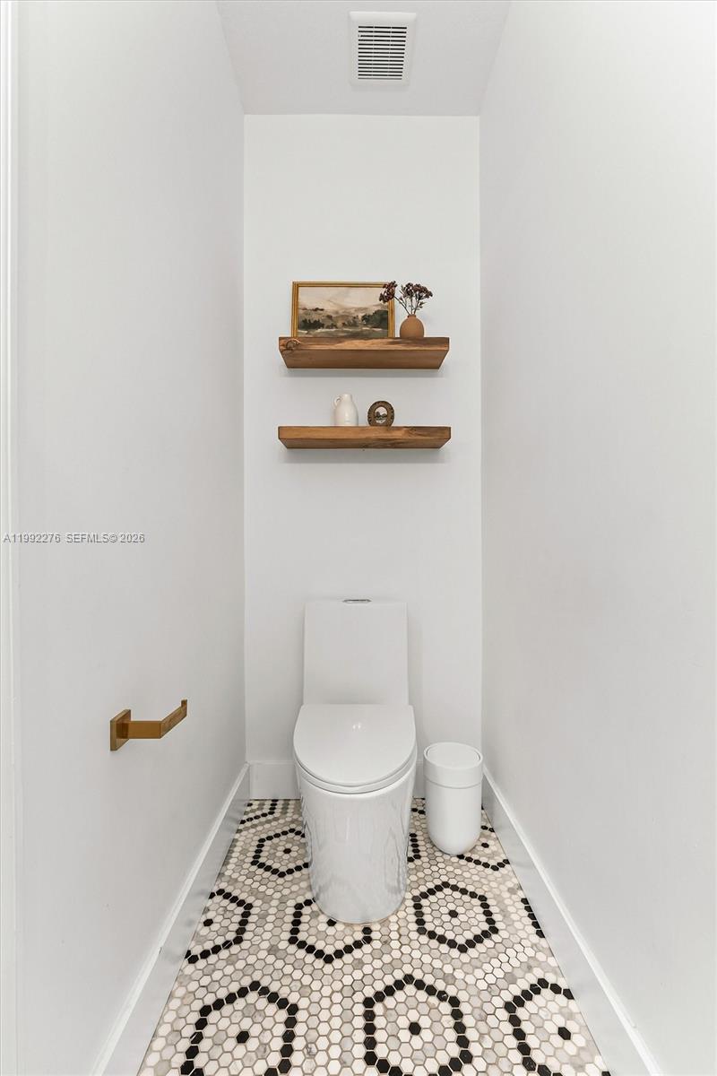 10487 West 34th Court Hialeah, FL 33018 - Photo 17 of 57 a bathroom with a toilet and a picture