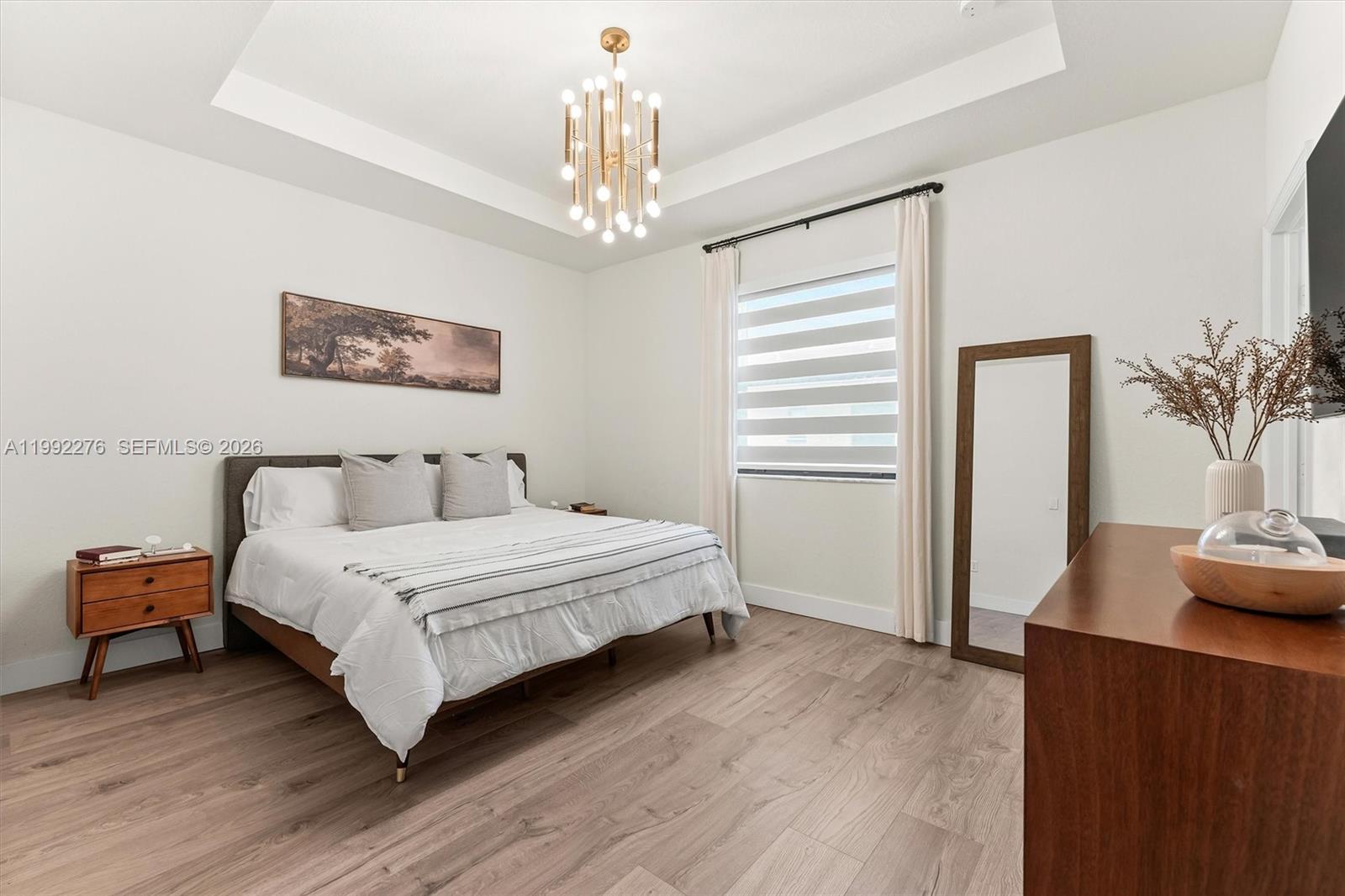 10487 West 34th Court Hialeah, FL 33018 - Photo 21 of 57 a spacious bedroom with a bed and a chandelier