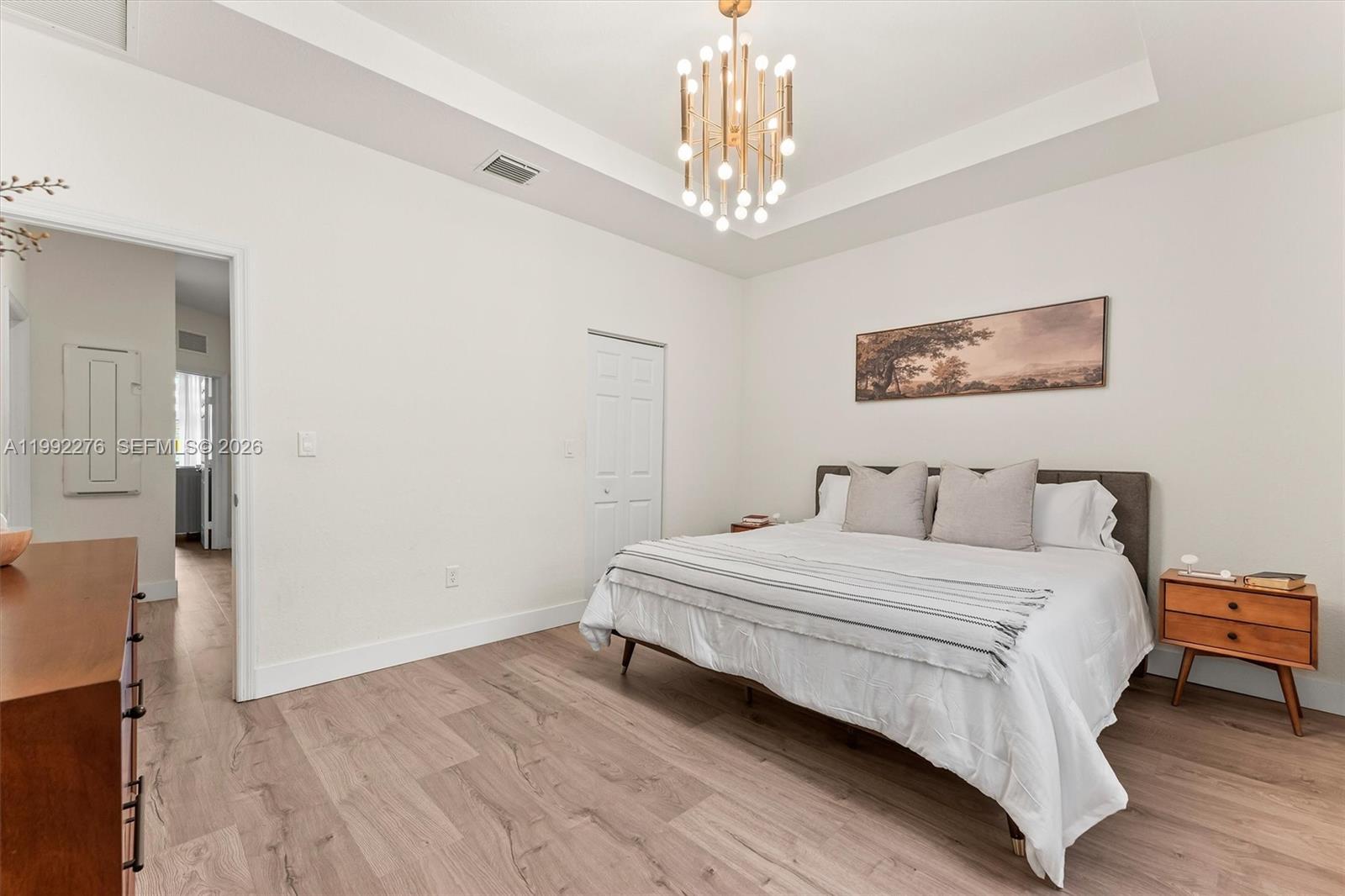 10487 West 34th Court Hialeah, FL 33018 - Photo 22 of 57 a bedroom with a large bed and a chandelier
