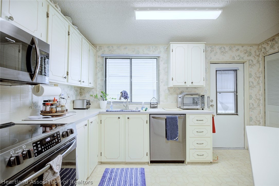 1571 Caribbean Road Sebring, FL 33870 - Photo 12 of 41 a kitchen with a stove and a sink