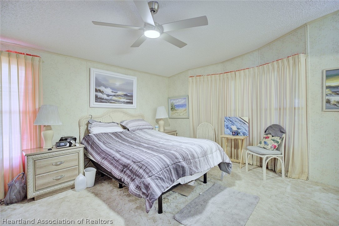 1571 Caribbean Road Sebring, FL 33870 - Photo 19 of 41 a bedroom with a bed and a chandelier