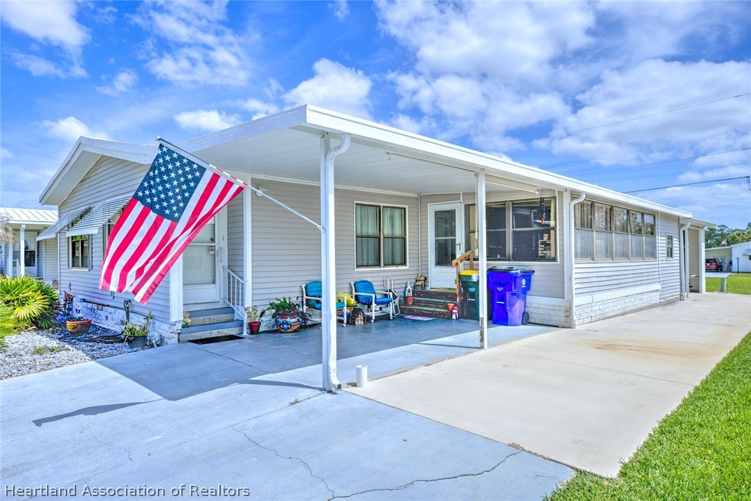 1571 Caribbean Road Sebring, FL 33870 - Photo 2 of 41 a view of a house with a patio and a yard