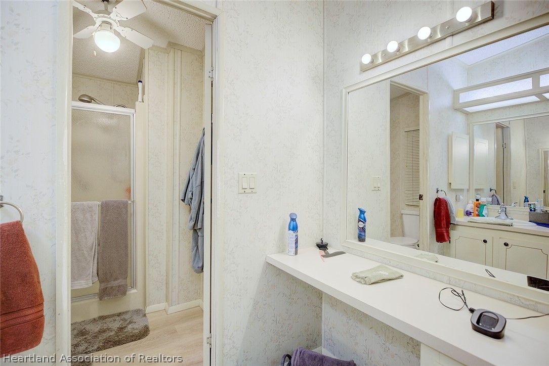 1571 Caribbean Road Sebring, FL 33870 - Photo 22 of 41 a bathroom with a sink vanity granite shower and a mirror