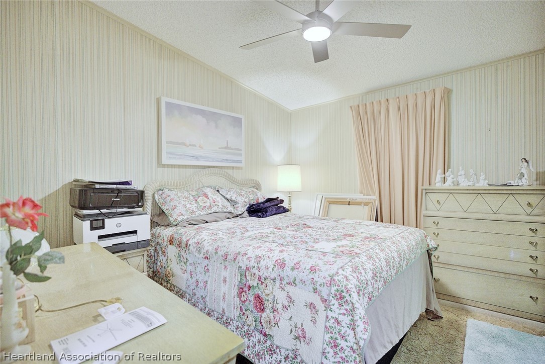 1571 Caribbean Road Sebring, FL 33870 - Photo 25 of 41 a bedroom with a bed and dresser with mirror