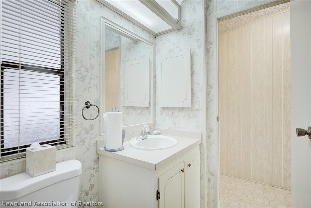 1571 Caribbean Road Sebring, FL 33870 - Photo 28 of 41 a bathroom with a granite countertop sink and a mirror