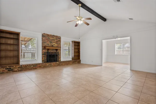 a view of an empty room with a fireplace and a window