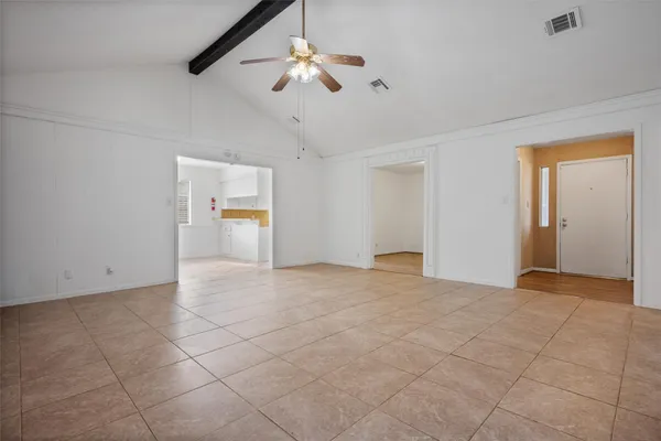 a view of an empty room with a ceiling fan and window