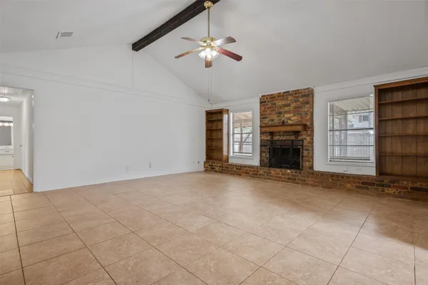 an empty room with fireplace and fan
