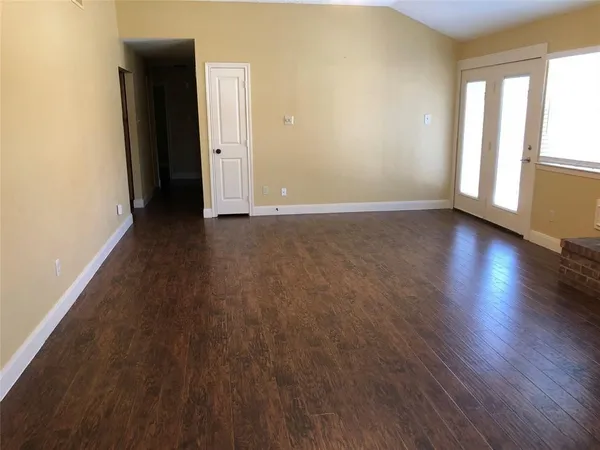 an empty room with wooden floor and fireplace