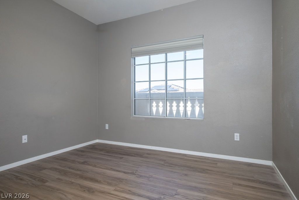 754 Solitude Point Avenue Henderson, NV 89012 - Photo 26 of 38 A well-lit room showcasing rich hardwood flooring and a large window overlooking the neighborhood.