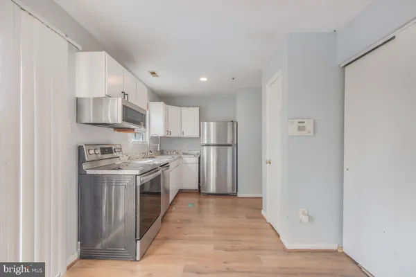 a kitchen with stainless steel appliances granite countertop a stove and a refrigerator