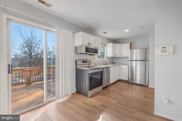 a kitchen with a refrigerator a sink and a stove top oven