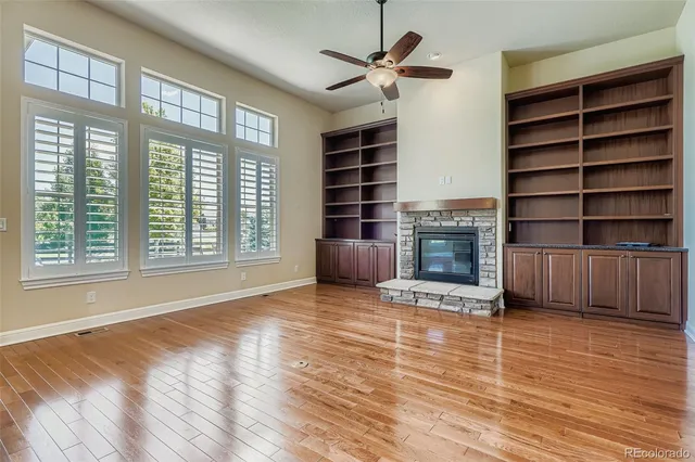 a view of an empty room with a fireplace and a window