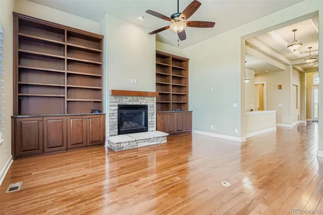a view of a livingroom with wooden floor a fireplace and a window