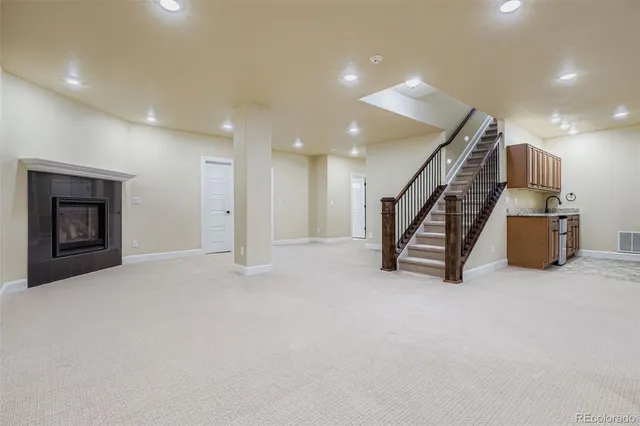 an empty room with wooden floor and stairs