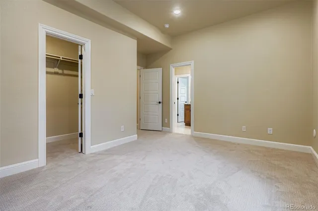 an empty room with closet and windows