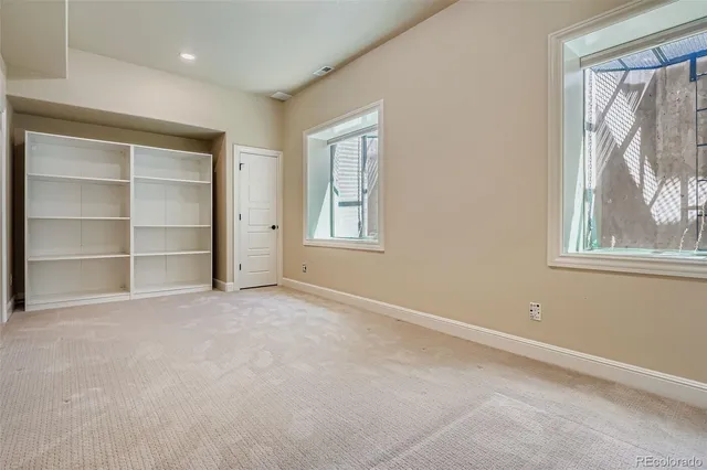 a view of an empty room with a window and closet