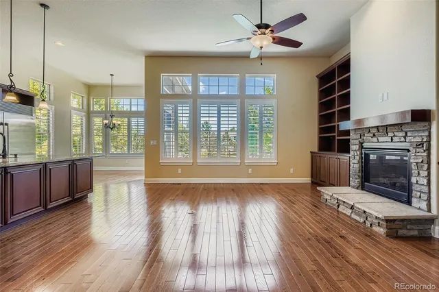 a living room with stainless steel appliances wooden floors and fireplace