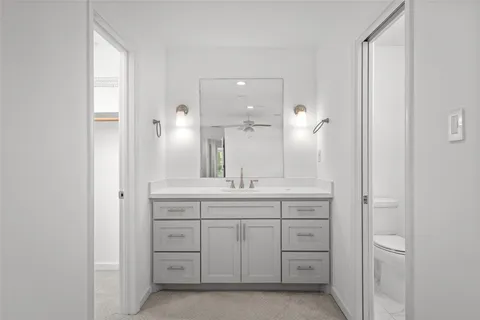 a bathroom with a granite countertop sink two mirror and a