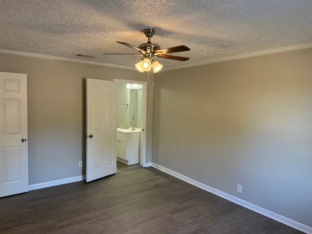 a view of a room with wooden floor and a ceiling fan