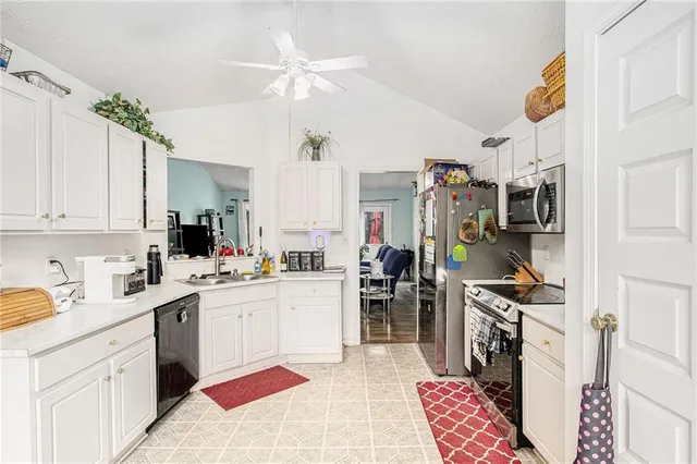 a kitchen with stainless steel appliances kitchen island granite countertop a sink a stove top oven a chimney cabinets and a counter top space