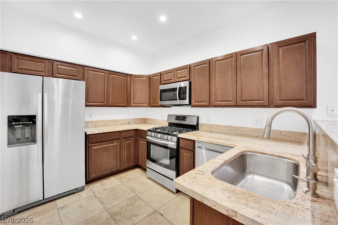 8725 West Flamingo Road, Unit 110 Las Vegas, NV 89147 - Photo 18 of 30 A well-appointed kitchen showcasing durable countertops, sleek appliances, and warm wood cabinetry.