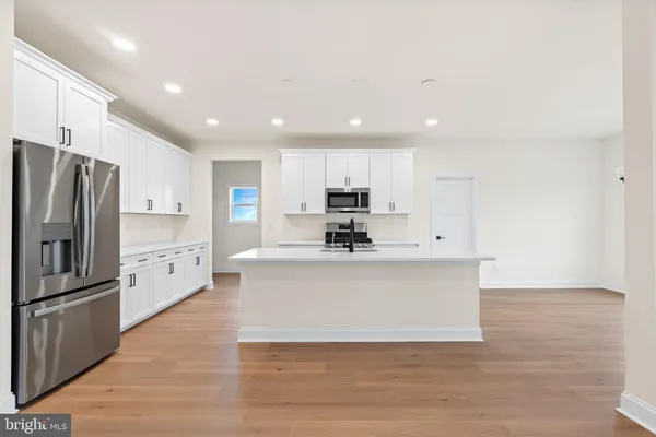 a view of kitchen with wooden floor and refrigerator