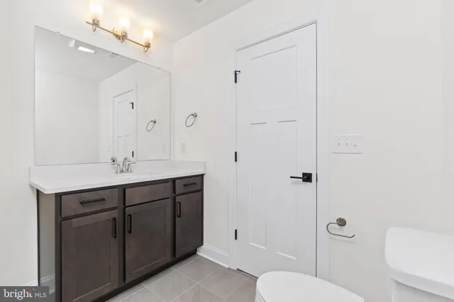 a bathroom with a toilet a sink and mirror