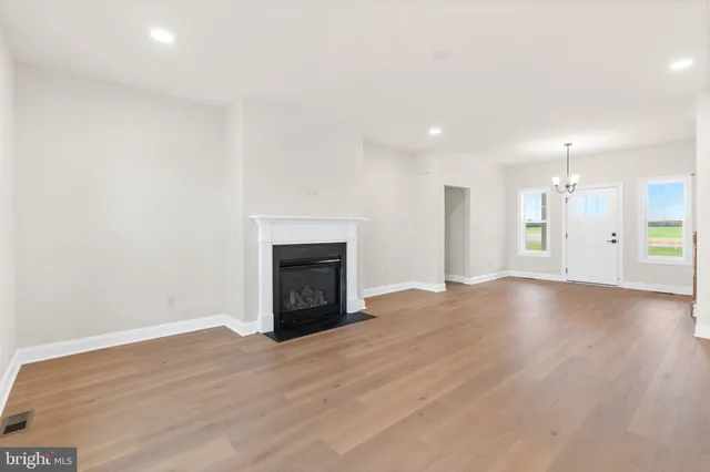 a view of empty room with wooden floor and fireplace