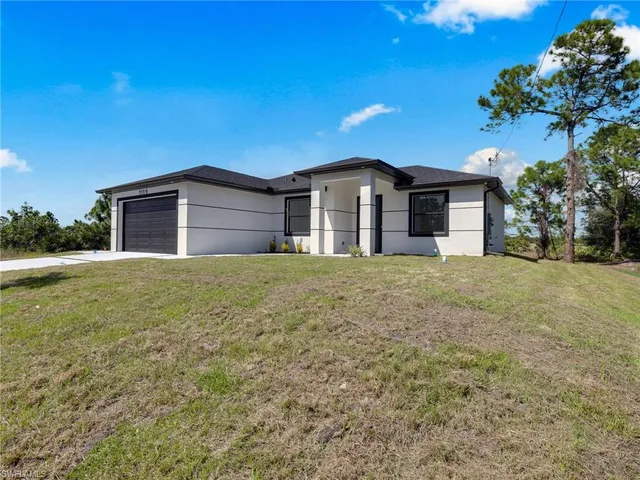 a large house with a big yard and large trees