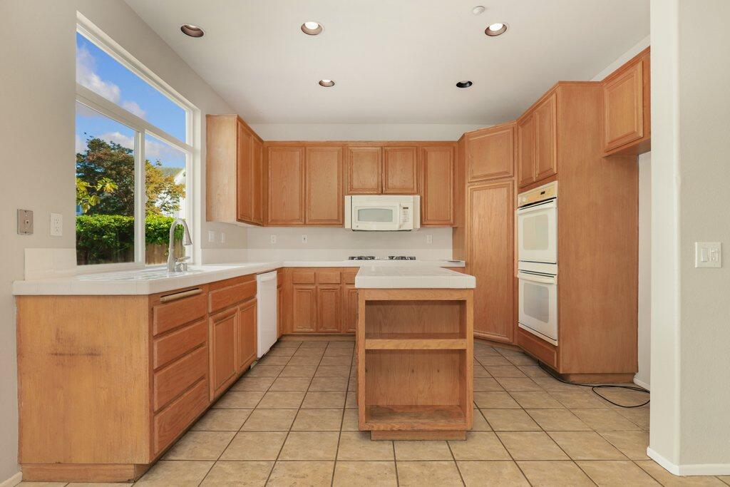 4695 Ellington Street Ventura, CA 93003 - Photo 12 of 43 a kitchen with stainless steel appliances a refrigerator sink and cabinets