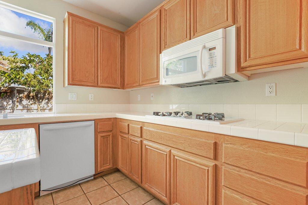 4695 Ellington Street Ventura, CA 93003 - Photo 14 of 43 a kitchen with granite countertop white cabinets and white appliances