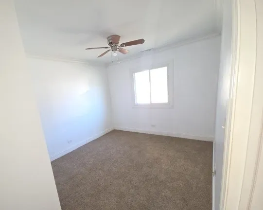an empty room with windows and fan