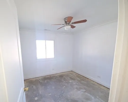 an empty room with a window and a fan