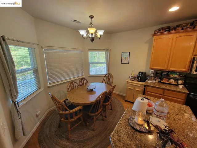 a kitchen with granite countertop a sink a stove top oven and wooden floor